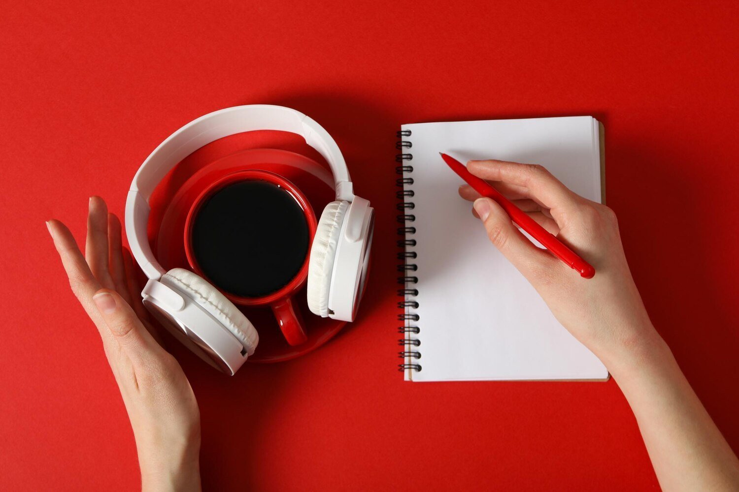 Casque audio et carnet sur fond rouge