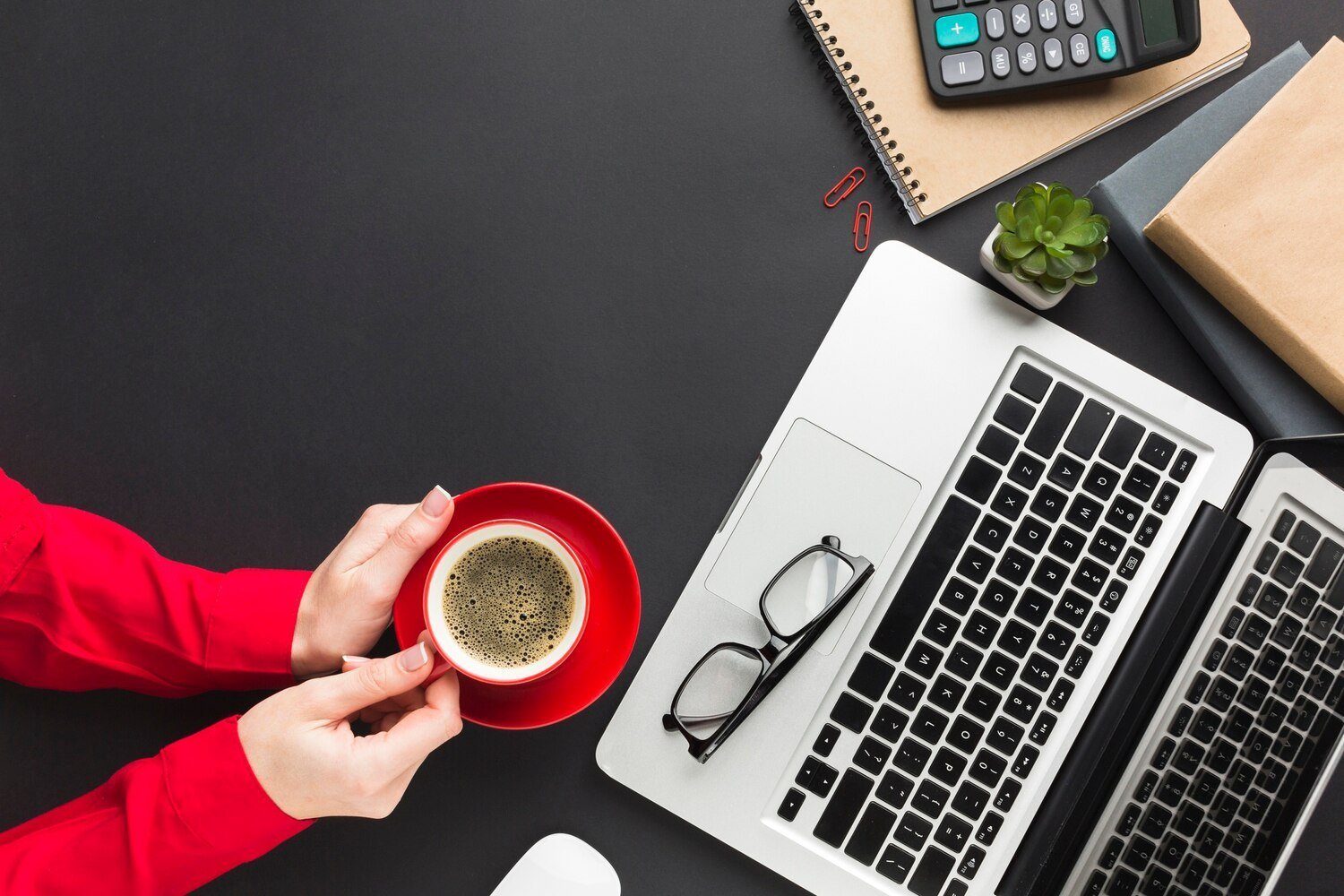 Mains tenant une tasse de café au-dessus d'un bureau
